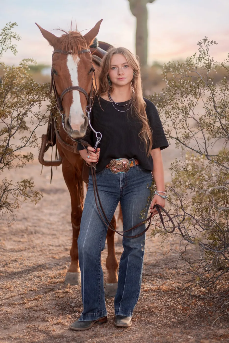 Senior portrait of a young woman leading her chestnut horse through the desert at sunset, by Casa de Baca Studios Senior portrait of a young woman leading her chestnut horse through the desert at sunset, by Casa de Baca Studios